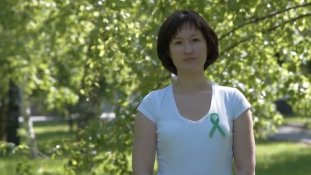 Молодая женщина с зеленой лентой осведомленности — стоковое видео