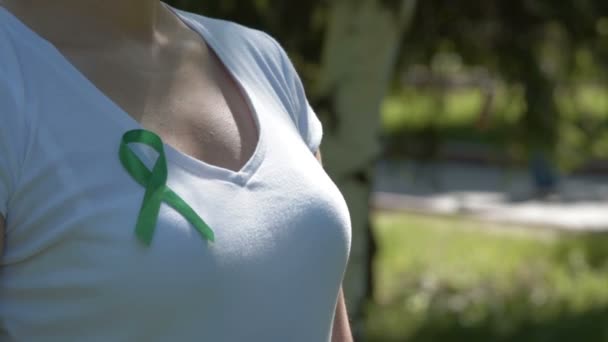 Chica vistiendo cinta verde de conciencia — Vídeo de stock
