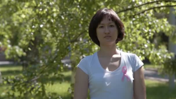 Young woman with pink awareness ribbon — Αρχείο Βίντεο