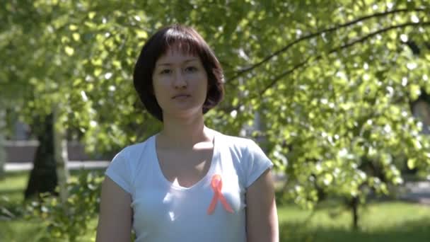 Молодая женщина с оранжевой лентой — стоковое видео