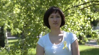 Young woman with yellow awareness ribbon