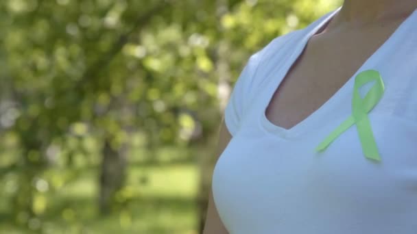 Girl wearing lime green awareness ribbon — Stock Video