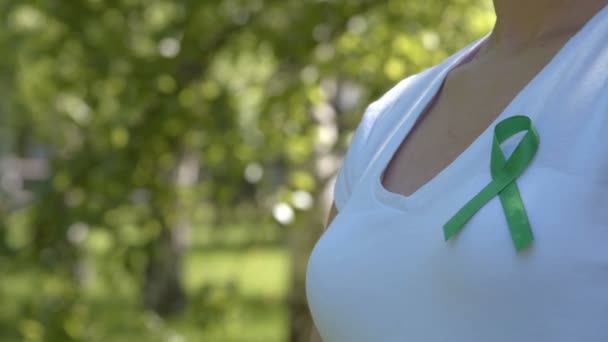Fille portant un ruban de sensibilisation vert — Video