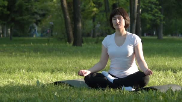 Mädchen macht Yoga im Park bei Sonnenuntergang — Stockvideo