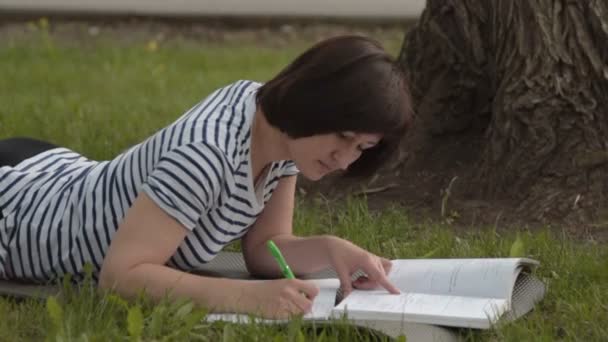 Estudiante femenina estudiando en el parque — Vídeos de Stock