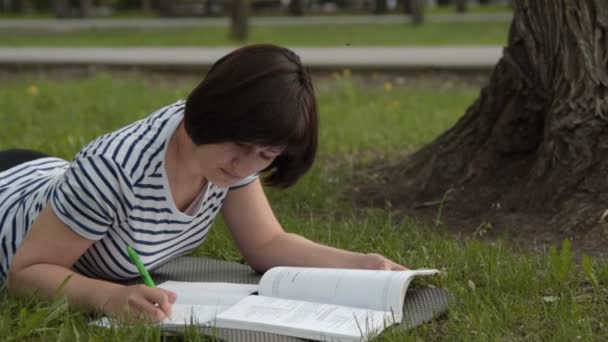 Tyttö opiskelee ulkona . — kuvapankkivideo