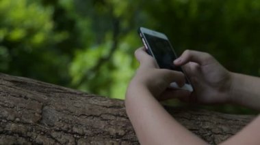 Parkta akıllı telefon kullanan kız