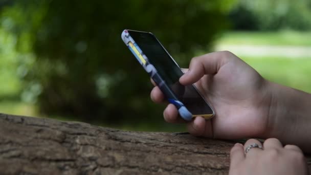 Menina com telefone inteligente navegação na web ao ar livre — Vídeo de Stock