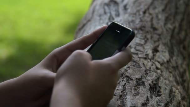Дівчина, що вводить повідомлення на мобільний телефон — стокове відео