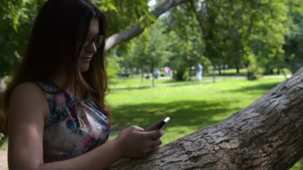 屋外の携帯電話での web ブラウジングの女の子 — ストック動画