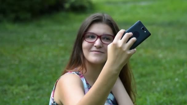 Tiener meisje mobiele selfie maken in het park — Stockvideo