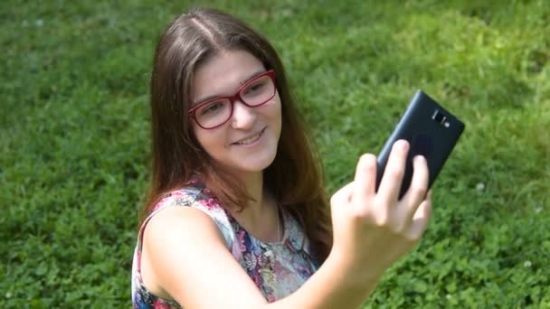 Mosolygós tinédzser lány vesz selfie-val szúró telefon — Stock videók