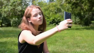 Selfie alma ve cep telefonuyla parkta kız