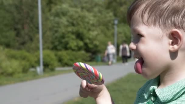 Litet barn med lollipop utomhus — Stockvideo