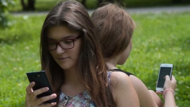 Друзья-подростки заняты просмотром веб-страниц на мобильных телефонах — стоковое видео