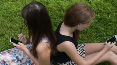 Genç kızlar cep telefonlarıyla Park
