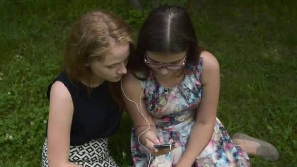 Chicas adolescentes escuchando música con teléfono celular — Vídeos de Stock