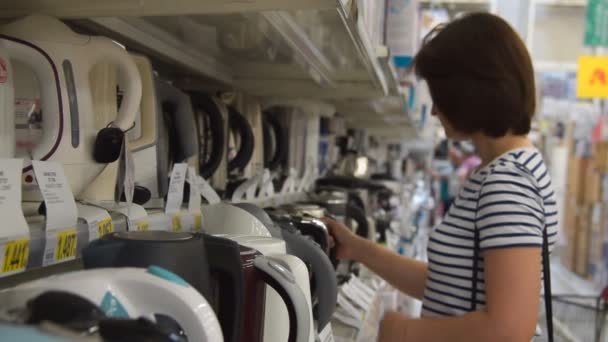 Donna che guarda bollitori nel negozio di elettrodomestici — Video Stock