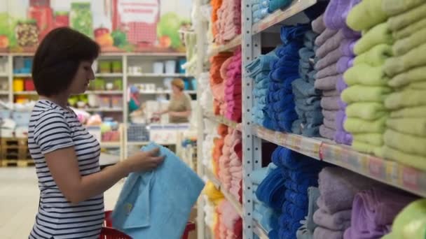 Mujer comprando toalla de baño en el hipermercado — Vídeo de stock