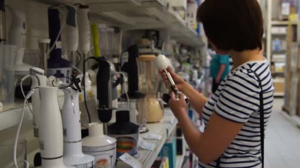 Женщина выбирает блендер в магазине — стоковое видео