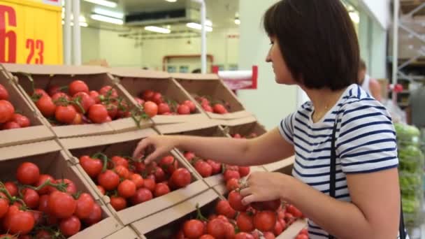 Mujer comprando tomates en el supermercado — Vídeos de Stock