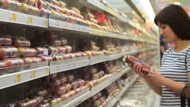 Mujer eligiendo salchicha en la tienda — Vídeos de Stock