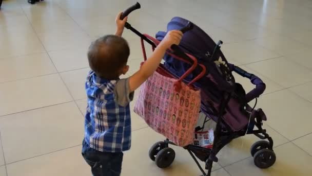 Niño con carro de bebé — Vídeo de stock