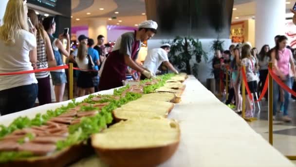 Cocineros jóvenes haciendo sándwich largo — Vídeos de Stock