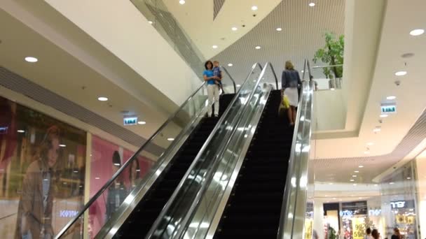 Personas en escaleras mecánicas en el centro comercial — Vídeo de stock