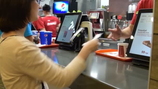 Vrouw betaalt voor de bestelling in KFC — Stockvideo
