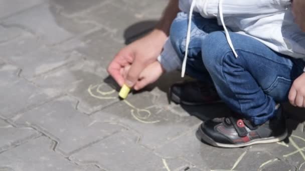 Père et fils dessinent sur le trottoir — Video