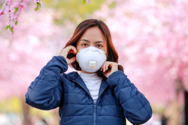 Corona virüsü Japonya 'da Corona virüsünden (COVID-19) korunmak için cerrahi maske takan genç bir Asyalı kadının portresi. Koronavirüs salgınından sonra turistler Asya 'ya seyahat ediyor..