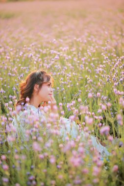 Lavanta tarlasında uzun sarı saçlı bir kadın. Stil hayatı, yaz günlerinde uzun beyaz elbiseli ve rahatlamış bir şekilde seyahatin tadını çıkarır..