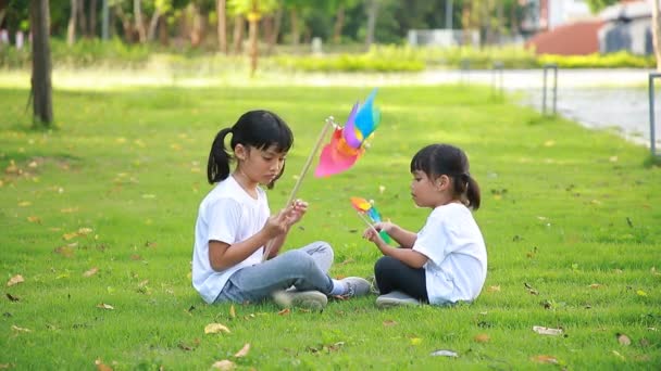 Bonito Menina Asiática Jogando Moinho Vento Brinquedo Colorido Suas Mãos — Vídeo de Stock