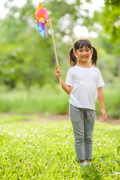 Gadis Kecil Yang Lucu Bermain Kincir Angin Mainan Berwarna Warni — Stok Foto
