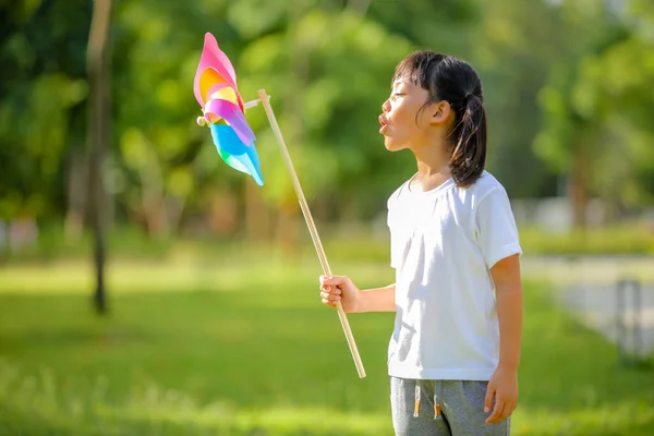 Schattig Klein Meisje Spelend Kleurrijke Speelgoedmolen Haar Handen Bij Het — Stockfoto