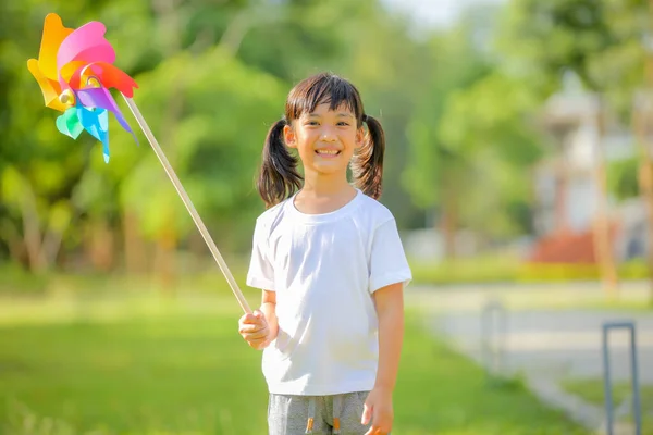 Linda Niña Jugando Colorido Molino Viento Juguete Sus Manos Césped — Foto de Stock