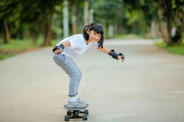 可爱的小女孩在滑板公园玩滑板或冲浪滑板 这增加了学习技能 体育活动生活方式概念 健康和锻炼的发展和提高 — 图库照片