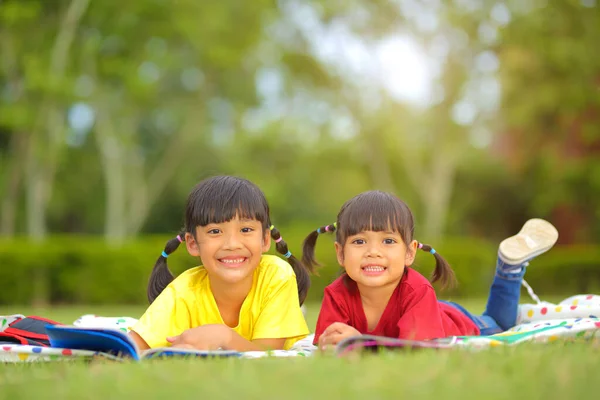 Linda Niña Leyendo Libros Hierba Ella Tiene Una Mirada Disfrute — Foto de Stock