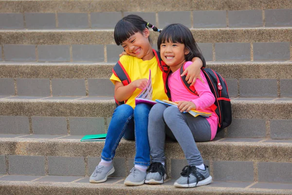Маленькая Азиатка Счастлива Улыбаясь Маленькой Друзьями Сидящими Лестнице Повышает Развитие — стоковое фото