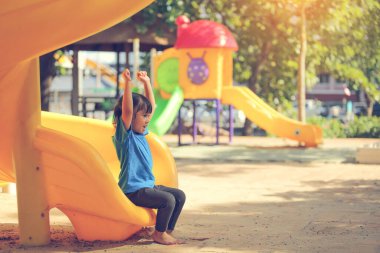 Neşeli, neşeli küçük kız yaz aylarında oyun parkında dolaşır. Açık hava aktivitesi. İnandırıcılık ve dış eğitim konsepti..