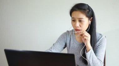 Kız öğrenci, öğretmeniyle internetten ders çalışıyor, mutlu genç kadın, dil öğreniyor, ders dinliyor, Webinar 'ı not yazıyor odasında oturan dizüstü bilgisayarına bakıyor, uzaktan eğitim görüyor..