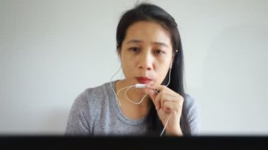 Kız öğrenci, öğretmeniyle internetten ders çalışıyor, mutlu genç kadın, dil öğreniyor, ders dinliyor, Webinar 'ı not yazıyor odasında oturan dizüstü bilgisayarına bakıyor, uzaktan eğitim görüyor..