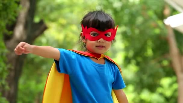 地球日的概念 一个可爱的小女孩的快乐和童年有自信的行动 穿着衣服 戴着面具 头戴超级英雄的斗篷 孩子们的梦想和想象力 — 图库视频影像