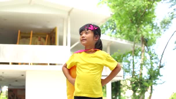 地球日的概念 一个可爱的小女孩的快乐和童年有自信的行动 穿着衣服 戴着面具 披着超级英雄的斗篷 — 图库视频影像