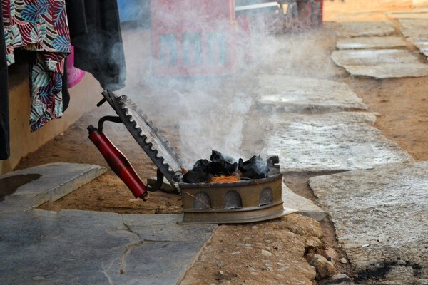 Уголь утюг все еще используется на индийской улице
