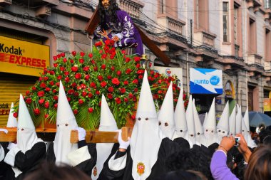 Penitents wear white hoods for the traditional Easter procession in colonial center, La Paz, Bolivia clipart