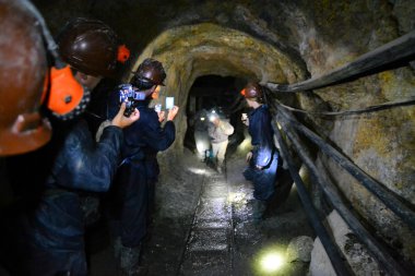 Tourists film miners inside of Cerro Rico mine in Potosi, Bolivia
