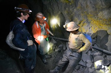 Tourists interview a miner inside silver mine, Potosi, Bolivia