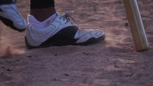 暖かい光の中で野球選手の足と地面でのバットのクローズアップ映像 — ストック動画